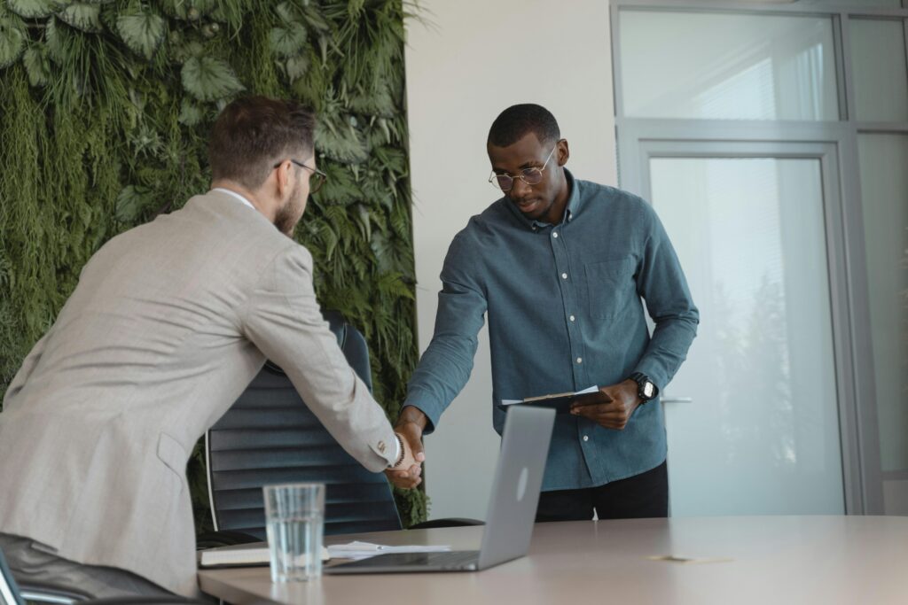 pexels-photo-5439439-5439439 Two businessmen shaking hands in a modern office setting, sealing a business agreement.